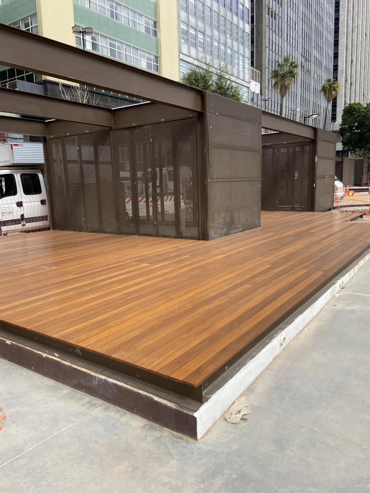 Plataforma de deck de madeira instalada no Vale do Anhangabaú, junto a estrutura metálica e aos prédios do centro de São Paulo